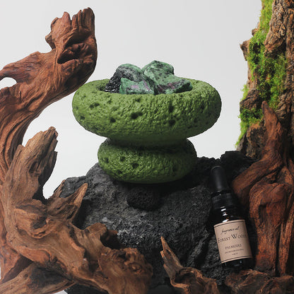 The Green Moon Diffuser surrounded by natural elements like leaves and wood.