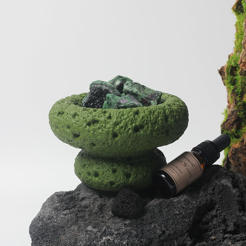 A beautifully styled rock displaying the Green Moon Diffuser with essential oils.